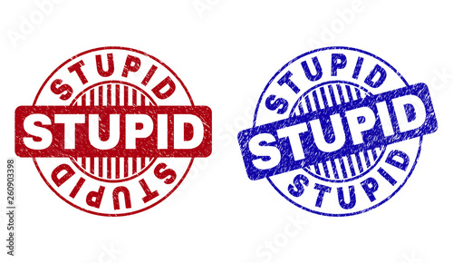 Grunge STUPID round stamp seals isolated on a white background. Round seals with distress texture in red and blue colors. Vector rubber overlay of STUPID label inside circle form with stripes.