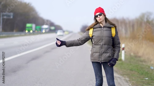                          Young pretty woman hitchhiking, finger up ,Travel team  photo