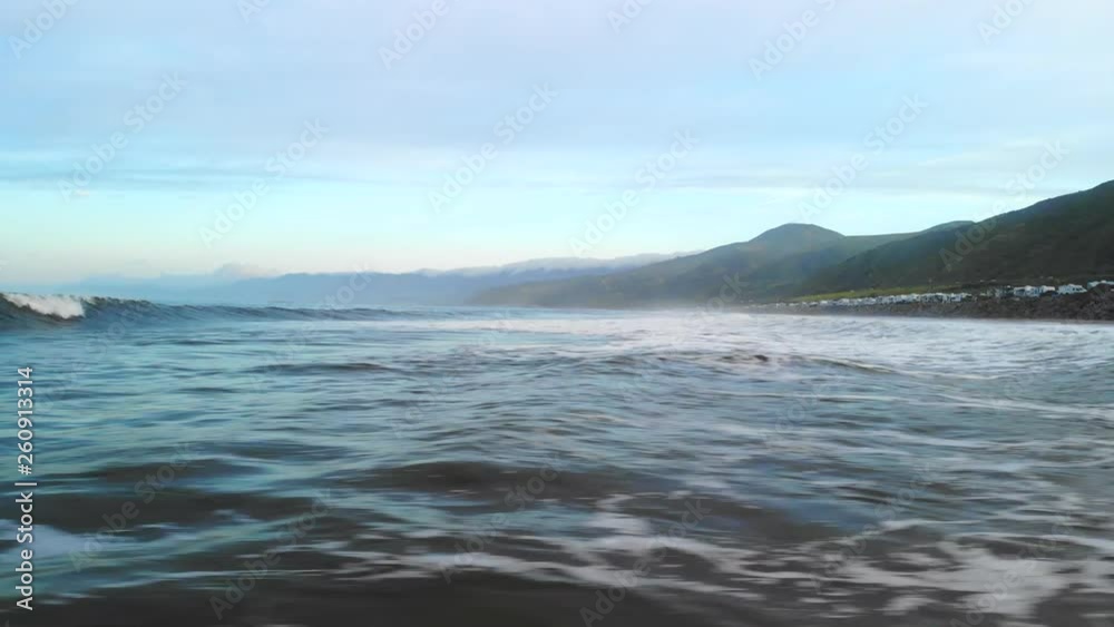 Aerial drone flying fast and low over the water surface of the Pacific ocean waves in Ventura California at sunrise. Aerial drone flying fast and low over the water surface of the Pacific ocean waves in Ventura California at sunrise.