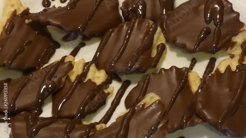 Slow pan over a plate of chocolate-covered potato chips drizzled with dark chocolate. photo