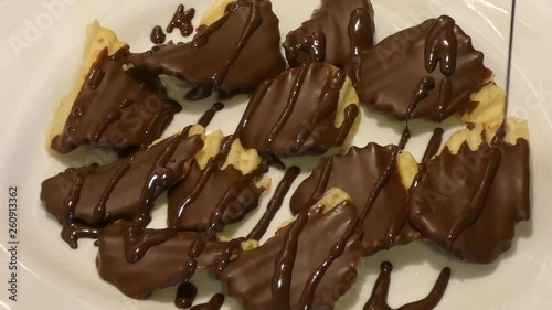 Dark chocolate is drizzled over chocolate-covered potato chips. photo