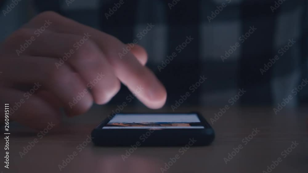 Man hand finger scroll on smartphone in dark. Man hand finger scroll on smartphone in dark.