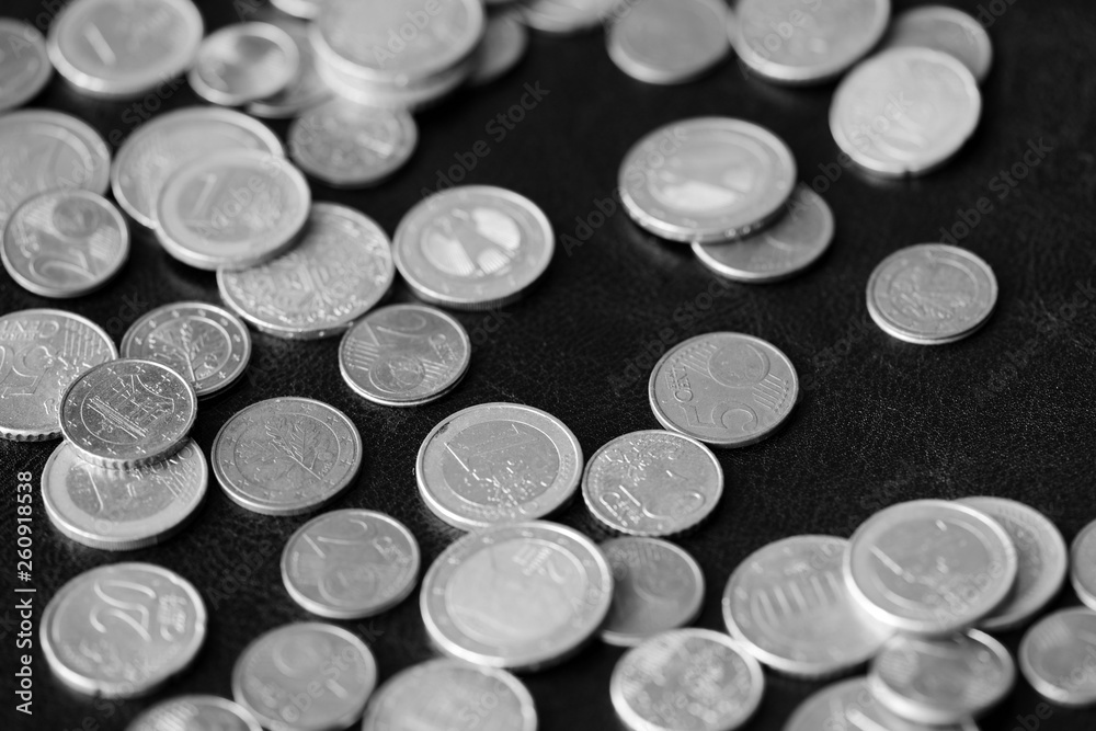 Euro coins scattered on a dark background close up. Black and white Euro coins scattered on a dark background close up. Black and white
