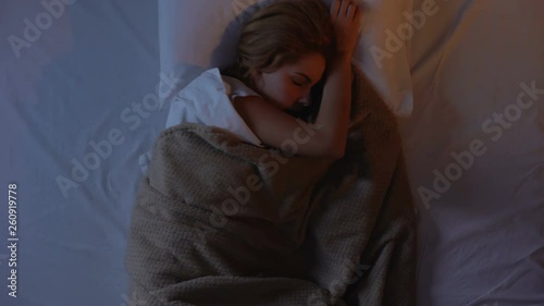 Female tossing and turning in bed, cant falling asleep because of noise outside