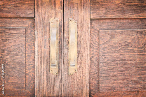 Old wood door with gold handle on brown background
