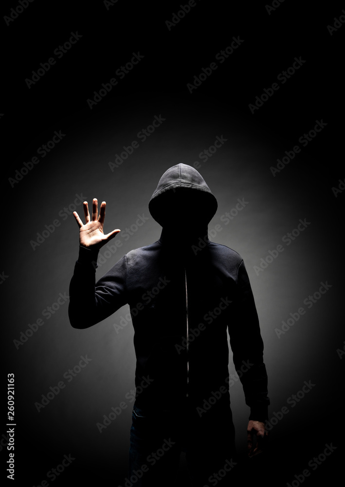 Computer hacker in hoodie. Obscured dark face. Data thief, internet fraud, darknet and cyber security concept. Computer hacker in hoodie. Obscured dark face. Data thief, internet fraud, darknet and cyber security concept.