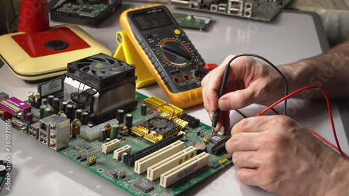 electronics technician is testing a computer chip. PC repair