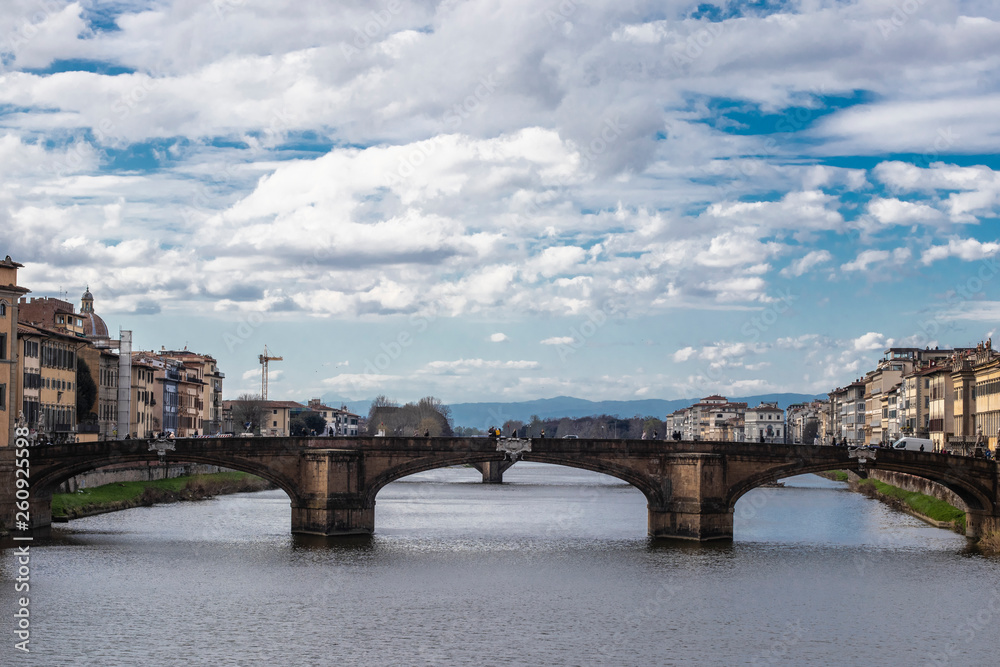 Old stone bridge in Firenze river skyline over a cloudscape, Italy