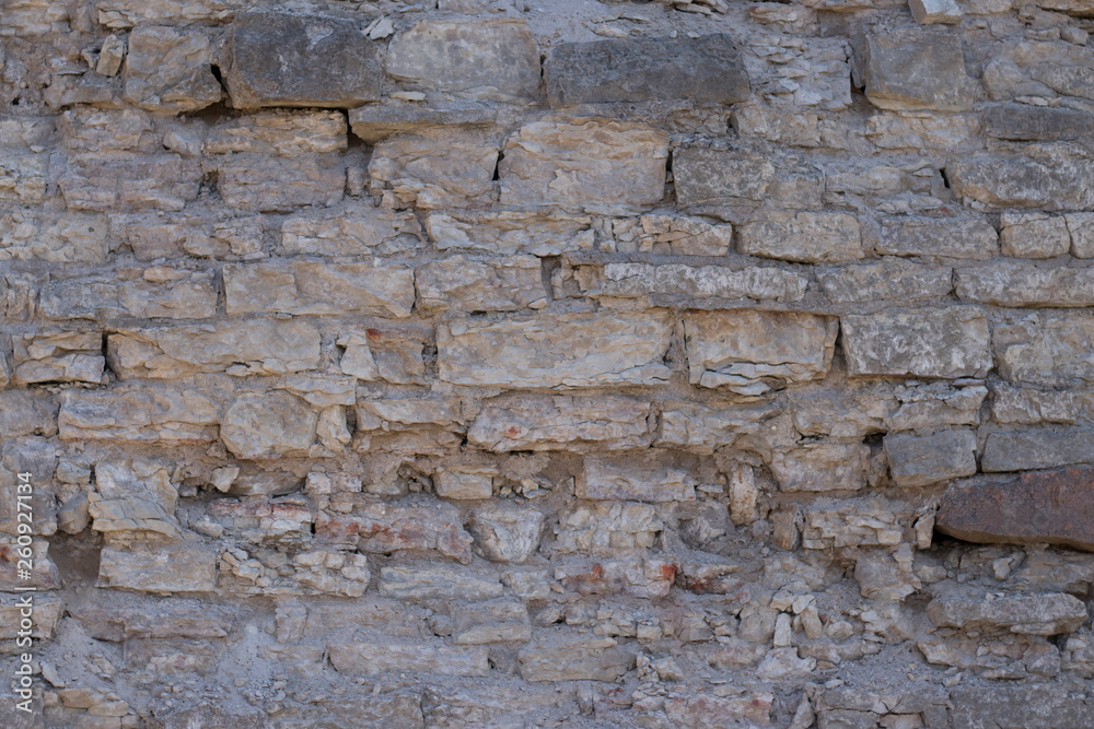 wall of an old crumbling grey stone blocks wall of an old crumbling grey stone blocks