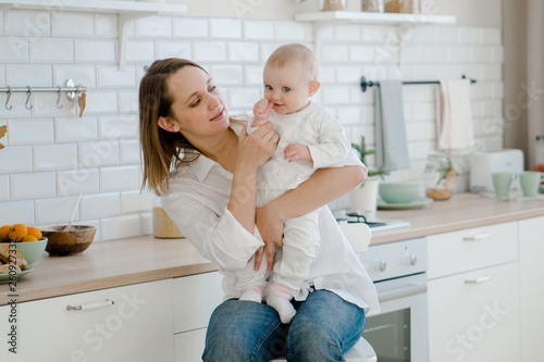 mom plays with her baby in the kitchen