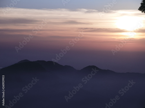 Sun set in Taiwans mountain region - Alishan mountain sun set in warm pastel colors with fog between mountain ranges © Johann