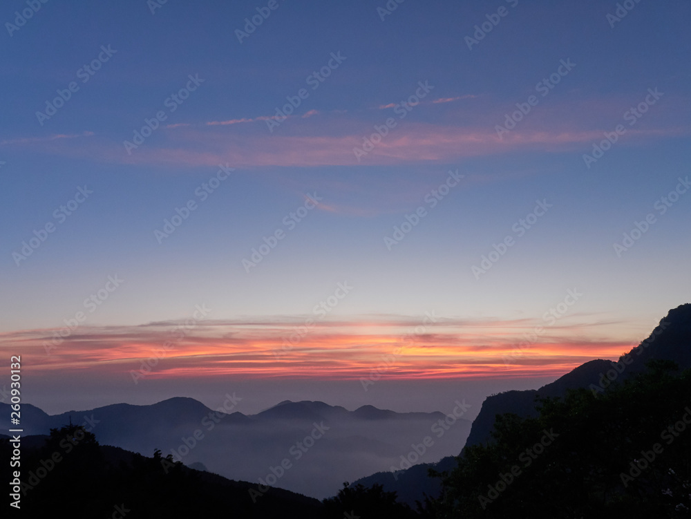 Sun set in Taiwans mountain region - Alishan mountain sun set in warm pastel colors with fog between mountain ranges