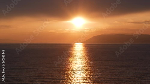 Orange sunset on beautiful calm Adriatic sea in Croatia with island Brac at background