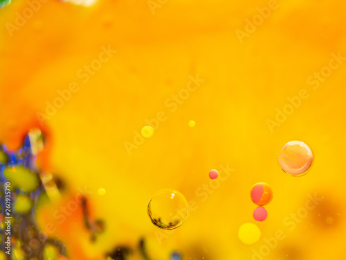 Spheres and multicolour pattern on abstract orange background. Close up macro shot. Blurred background. Selective soft focus. Abstract multicolour universe. Bubbles in space