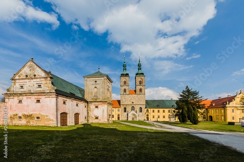 Tepla, Czech Republic / Europe - April 3 2019: Premonstratensian monastery founded in 12th century by Blessed Hroznata, abbey church made of stone with two towers, yellow convent, sunny day, blue sky