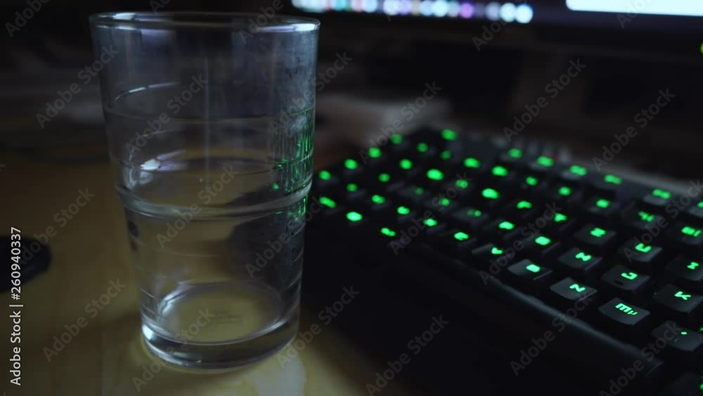 Pouring a glass of sparkling water on a computer desk Pouring a glass of sparkling water on a computer desk