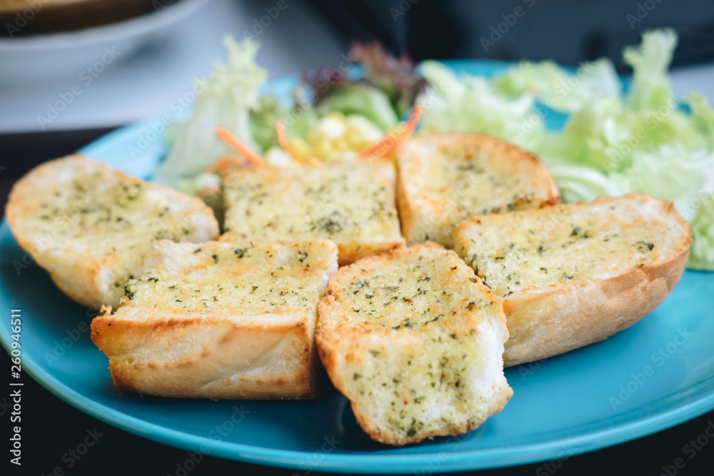 Garlic bread on the blue dish and vegetable salad