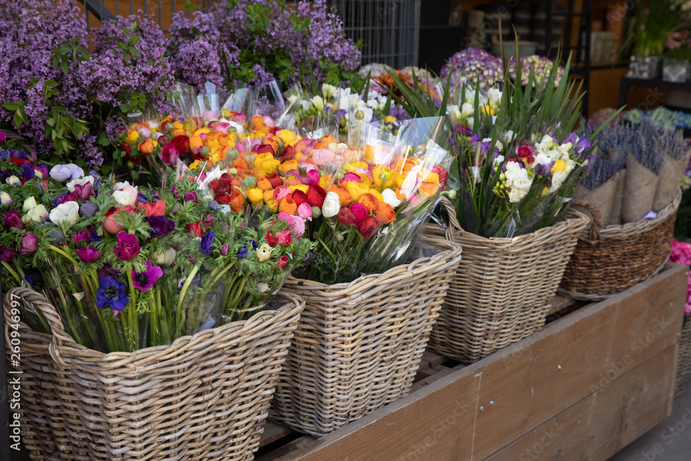 Everyday flowers counter with variety of fresh cut flowers such as anemone coronaria, persian buttercups, freesia, syringa branches, for home decor at the greek garden shop.