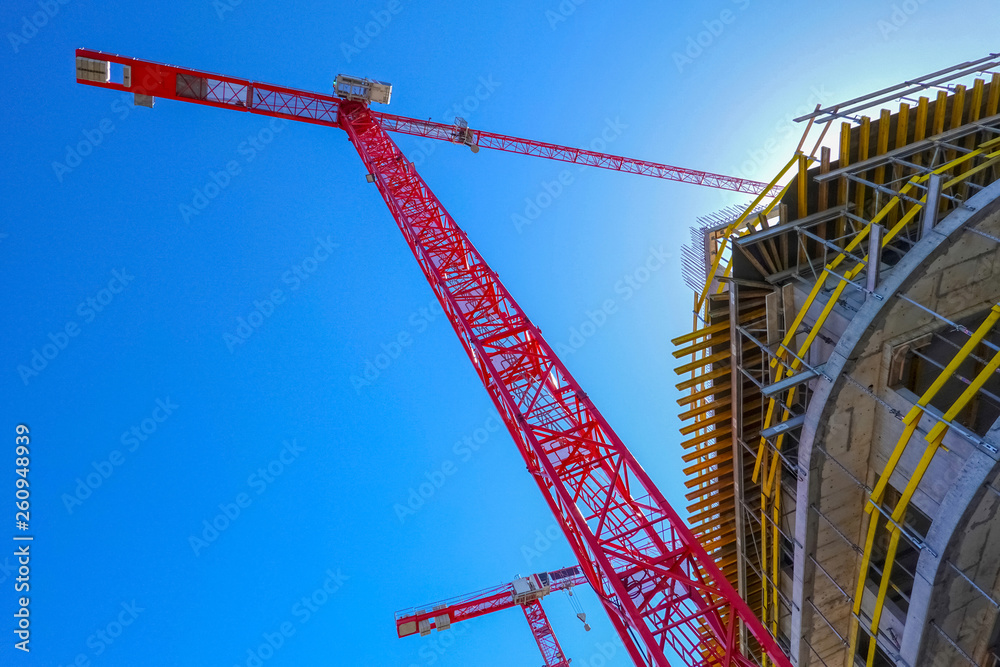 Construction cranes at house building site Construction cranes at house building site