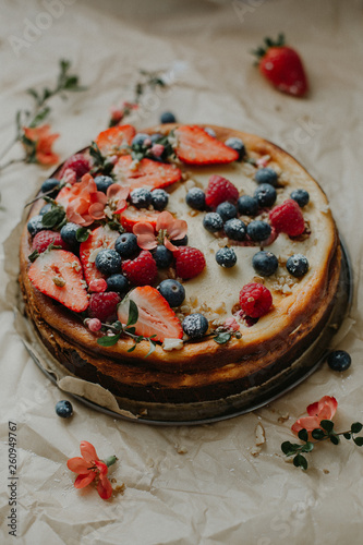 Selbstgemachte Käsekuchen mit frischen Beeren Erdbeeren Heidelbeeren Himbeeren auf Backpapier