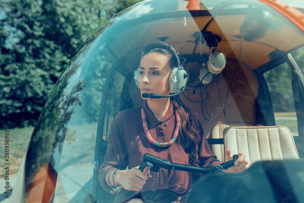 Concentrated good-looking female pilot wearing needed equipment - obrazy, fototapety, plakaty 
