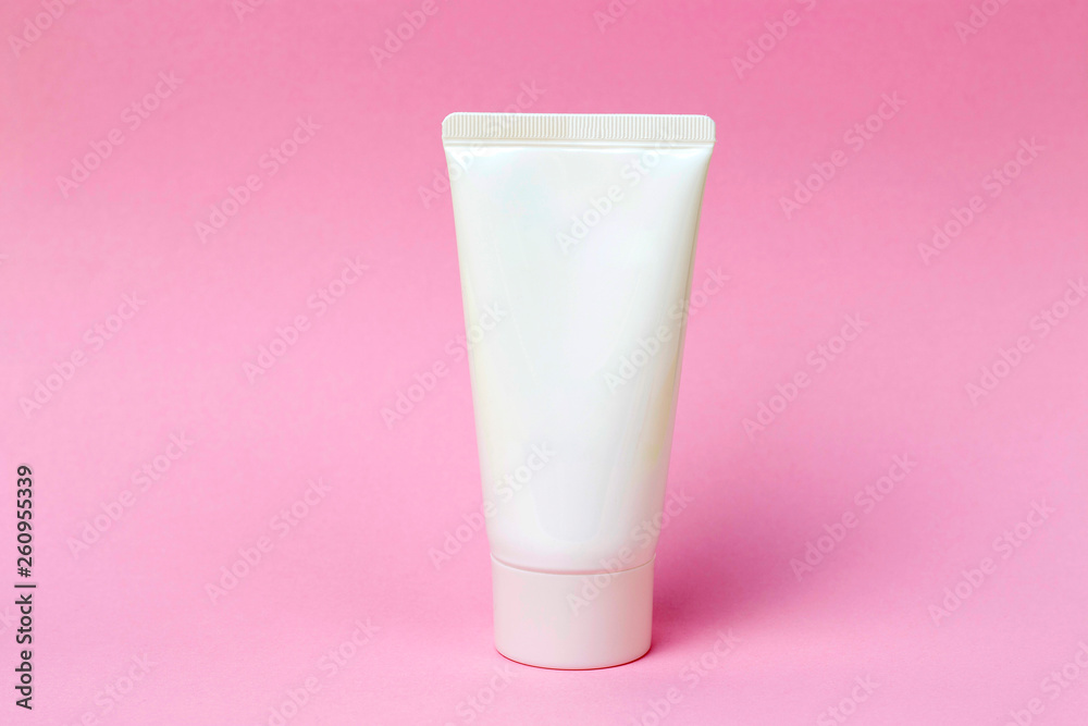 Tube with cream on a pink background, front view, cosmetics care concept Tube with cream on a pink background, front view, cosmetics care concept