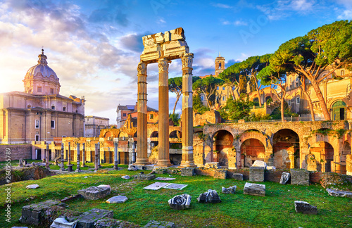 Roman Forum in Rome, Italy. Antique structures with columns and archs. Wrecks of ancient italian roman town. Church of Santi Luca e Martina. Sunrise above famous architectural landmark.