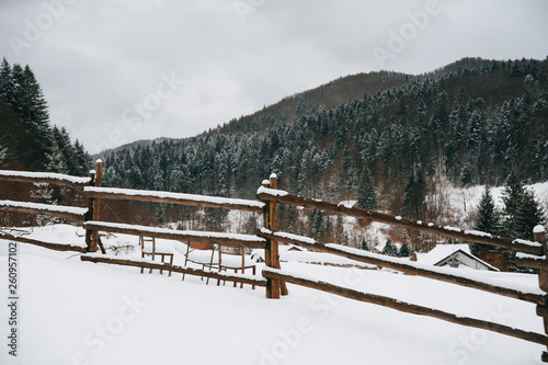 A winter landscape, top of the mountaine village, little fence, and forrest