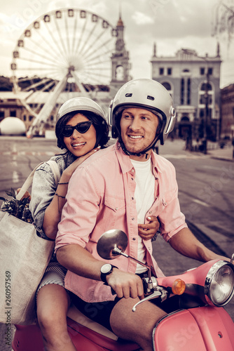 Positive nice couple riding a motorbike together