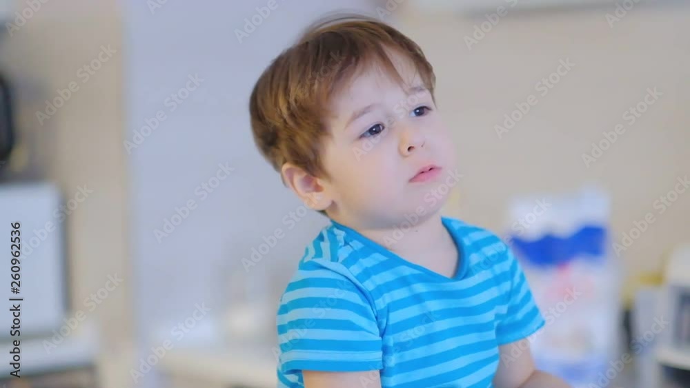 sad face boy three years old, sitting in the kitchen at home and talking into the camera sad face boy three years old, sitting in the kitchen at home and talking into the camera