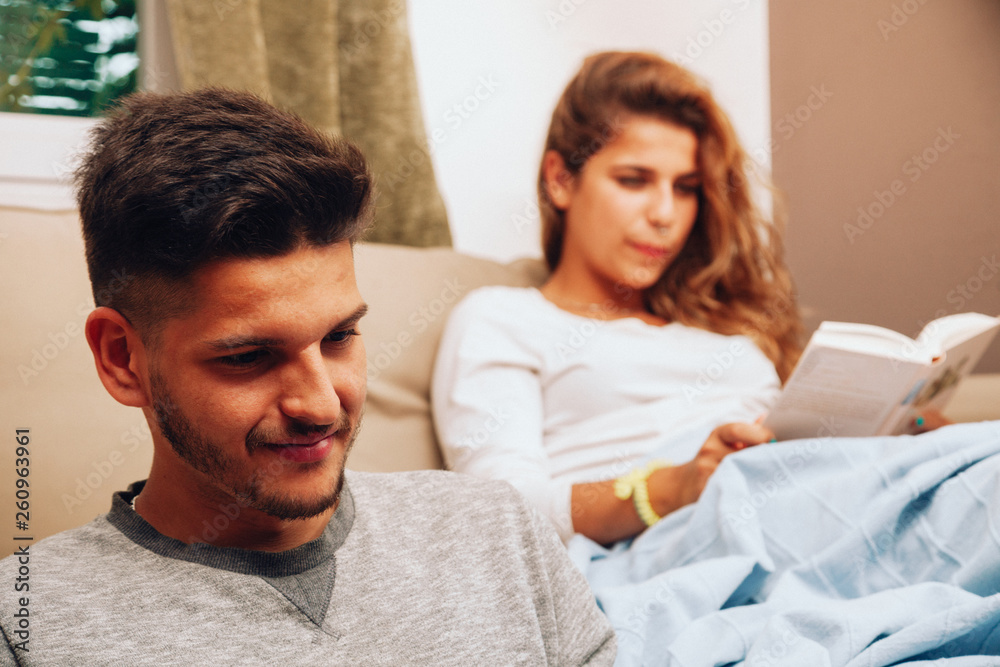 Young smiling heterosexual couple together on sofa Young smiling heterosexual couple together on sofa
