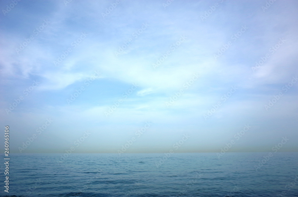 Blue seascape of Gulf of Oman seen from Arabian peninsula with yellow line of sandstorm over Iran Blue seascape of Gulf of Oman seen from Arabian peninsula with yellow line of sandstorm over Iran