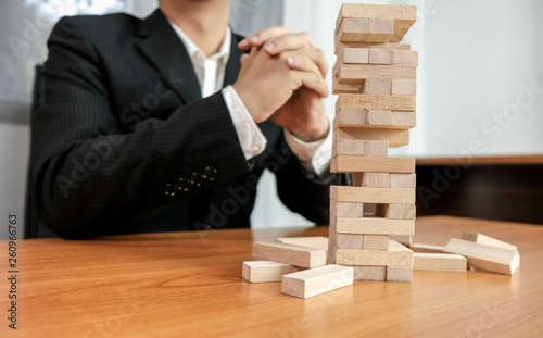 Planning risk and strategy in businessman gambling placing wooden block.Business concept for growth success process