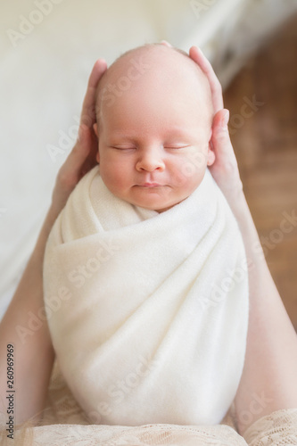Newborn baby boy sleeping in mom's arms