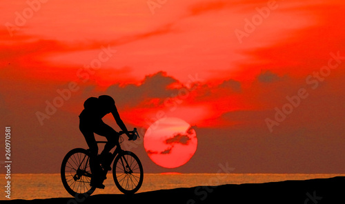 Silhouette man  and bike relaxing on blurry sky   background. © rathchapon