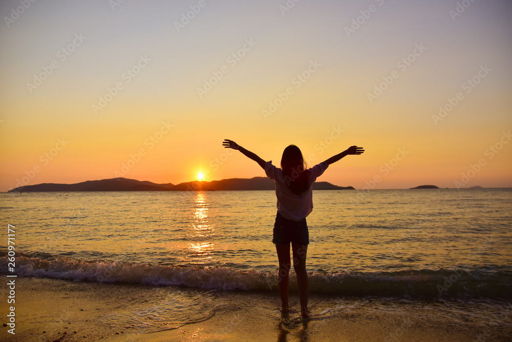 Women standing on beach at sea sunset background on evening golden hour.Travel summer holiday sea beach in Thailand