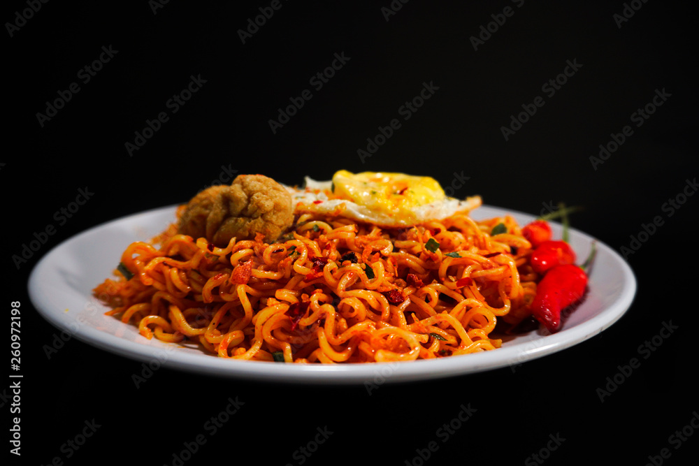 Spicy Noodle with meatball and egg isolated on black background