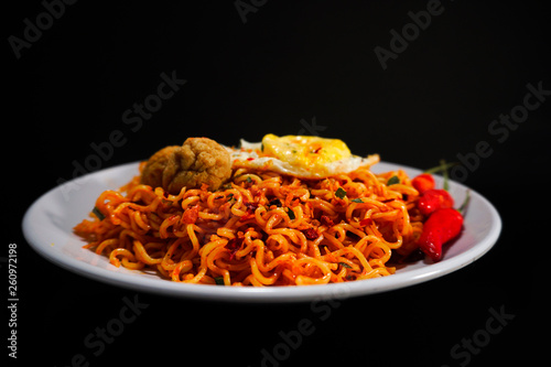 Spicy Noodle with meatball and egg isolated on black background