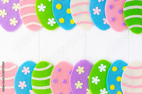 Closeup top view photo of cute diy colorful pastel eggs decorated with dots, stripes and flowers isolated on white painted wooden background. Happy Easter holiday greeting card. Horizontal photography