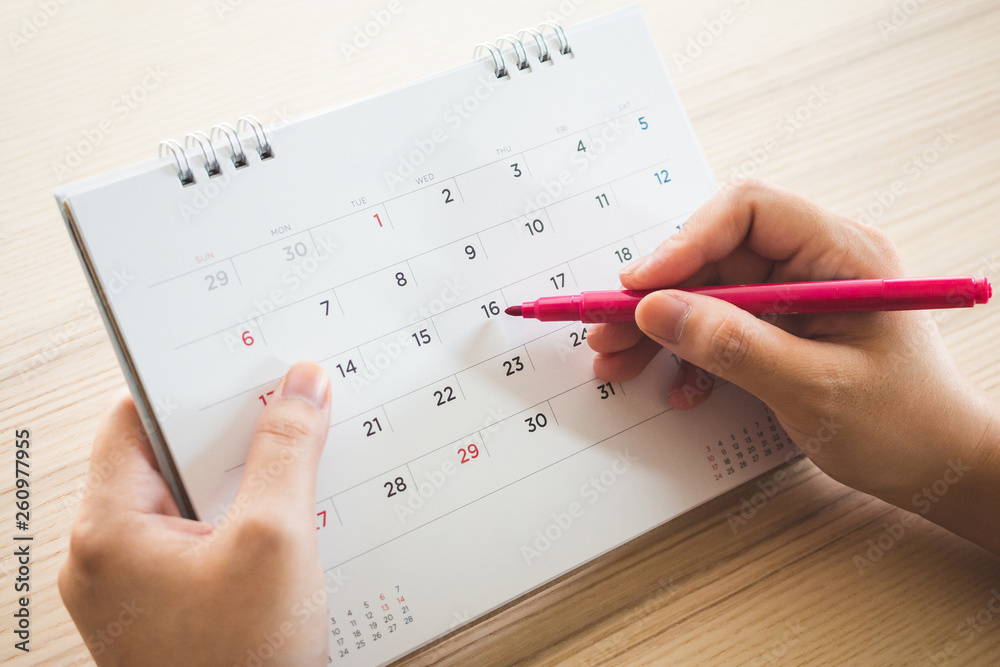 Hand with pen writing on calendar page closeup Stock Photo | Adobe Stock