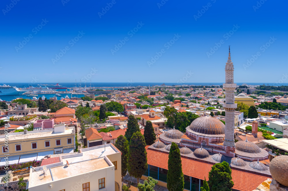 Panoramic view of the Rhodes medieval old city, with the historic Suleiman Mosque on the right and the Mandraki harbour in the background. Popular summer holiday destination in Greece.