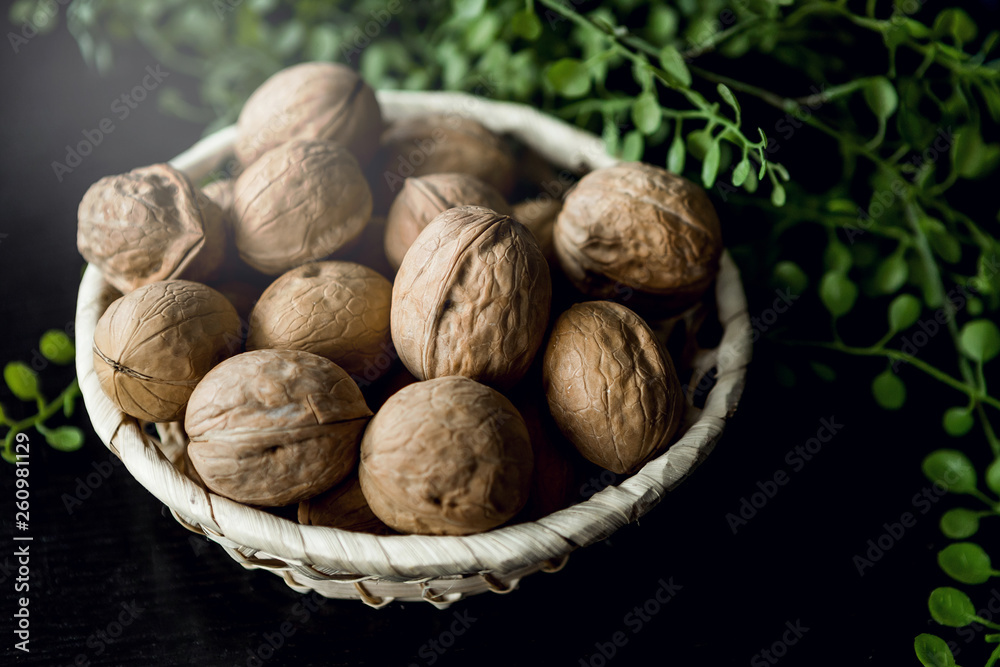 walnuts in a basket on a black background walnuts in a basket on a black background