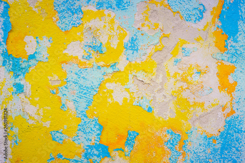 Close-up of old blue and yellow damage wall.