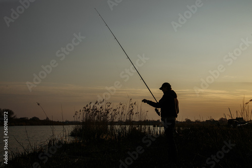 Silhouette of a fisherman against the sky