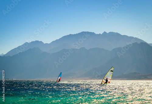 surfers ride in the sea on the background of the rocky coast in Egypt Dahab photo
