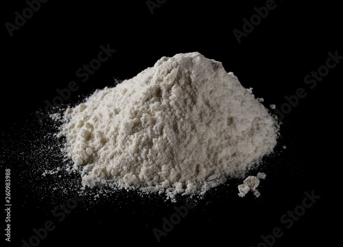 Wheat flour pile isolated on black background, powder texture