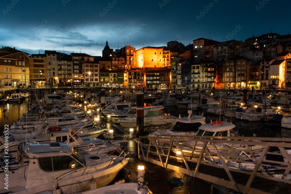Spanish village port at night with lights and boats. Bermeo, Basque Country