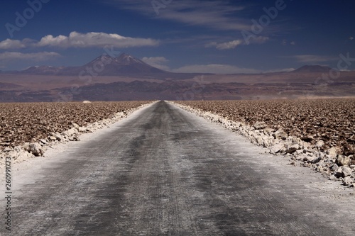 Endless dirt road with blurred horizon through salt flat "salar de Atacama" near San Pedro de Atacama, Chile