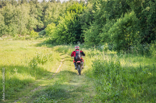 A man on a motocross bike rides along the forest © Michael Kachalov