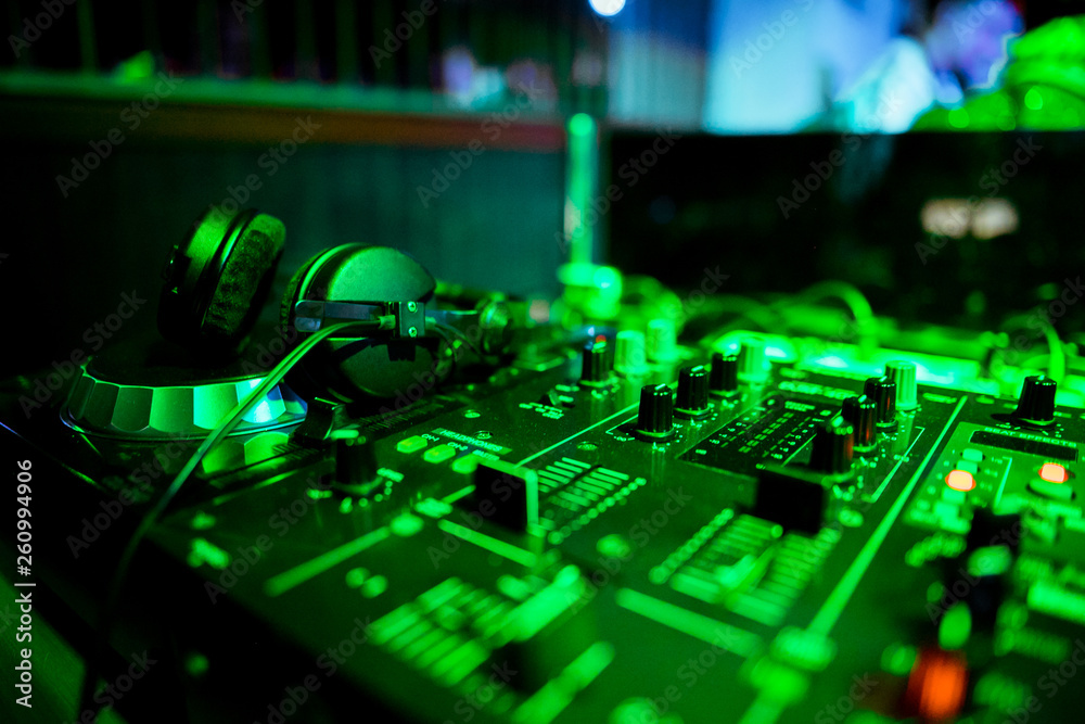 Night club, nightlife concept. DJ hands hold microphone and mixing DJ remote. Neon light